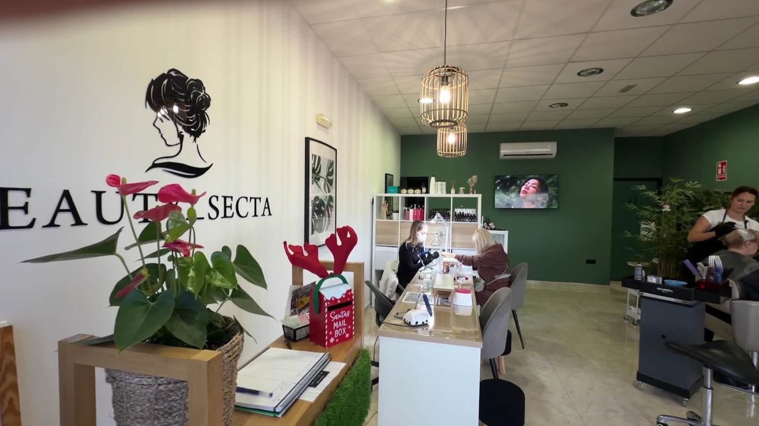 Sala principal con la pared verde y las mesas de manicura